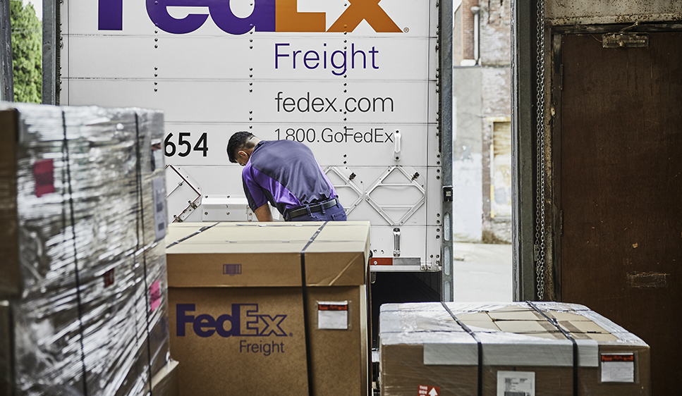 Delivery person unloading FedEx truck.