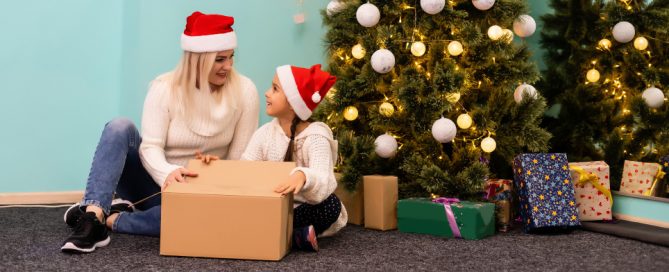 holiday gift shipping - mother and daugher in front of the christmas tree